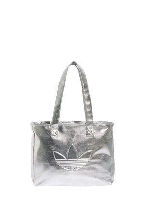 Sac cabas métallique argenté avec deux poignées et un grand logo Adidas trefoil embossé sur le devant.