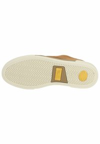 Zapato de ante marrón con una suela de goma texturizada, que presenta un patrón de espiga, un logo en el talón y un acento en contraste en tono tostado.