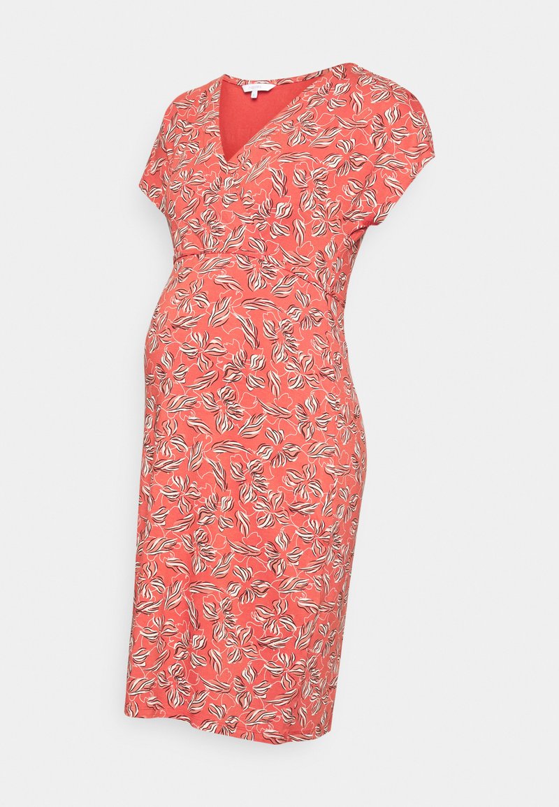 Vestido de maternidade em coral com um padrão floral, apresentando um decote em V, mangas curtas e uma cintura ajustada que acomoda uma barriga em crescimento.