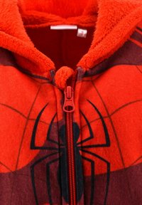 Red fleece hoodie with black spider logo and web patterns, featuring a central red zipper and soft fuzzy lining inside the collar.