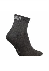 Ankle sock in dark gray, made from textured fabric. Features a ribbed cuff with "Puma" logo in light gray on the upper side.