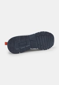 Must must kummipaelaga, millel on tekstuuriga pind, sügavad sooned ja punane tõmbluku riba kanna juures. "Beta" logo on otsitud põhjale.