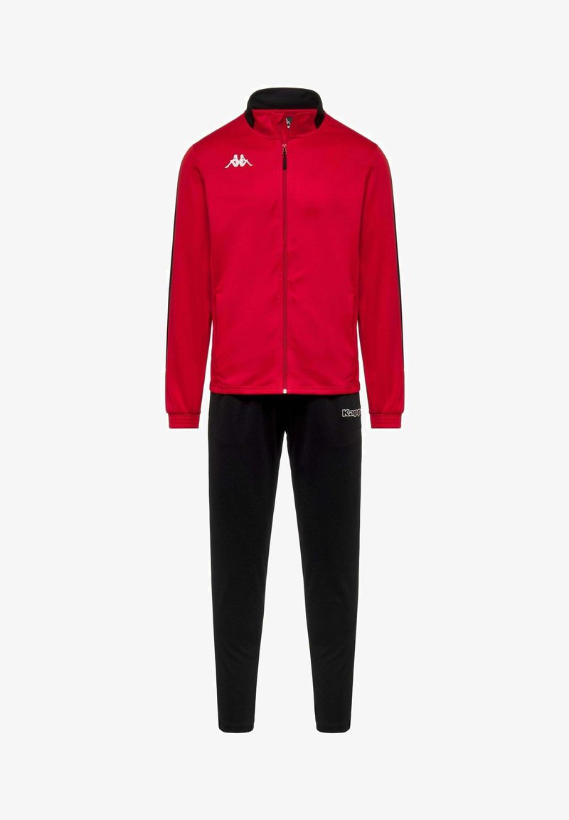 Veste rouge zippée avec logo blanc sur la poitrine, associée à un pantalon noir avec logo sur la cuisse, présentée sur fond blanc.