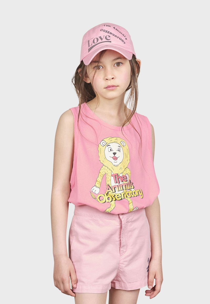 Top sin mangas rosa con un gráfico de un león y texto, combinado con pantalones cortos rosa claro. Una gorra rosa a juego presenta "The Animals Observatory" y "Love."