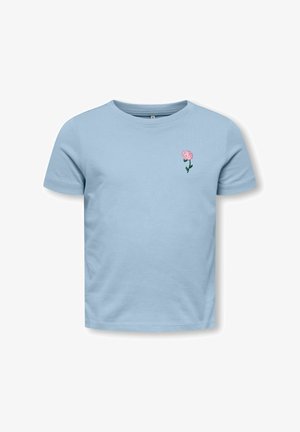 Magazine a manica corta azzurro chiaro con piccola ricamo di fiore rosa sul lato sinistro del petto, sfondo semplice.