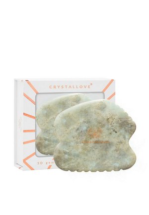 2 narzędzia do masażu w jadeitowej zieleni o gładkiej teksturze, z niewielkimi różnicami w wzorze, zapakowane w białe pudełko z geometrycznymi akcentami i brandingiem.