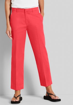 Bright coral women's pants with a straight-leg design, featuring front pockets and a smooth texture. Paired with black flip-flops.