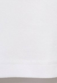 White cotton T-shirt fabric with a textured finish. Bottom hem features a clean stitch and slight curvature. No patterns or graphics visible.