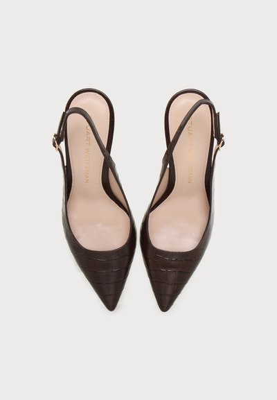 Paire d’escarpins slingback marron foncé à bout pointu avec texture crocodile et semelles intérieures beiges sur fond clair.