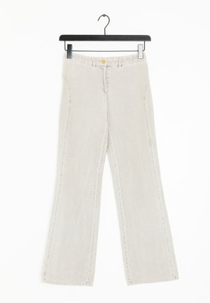 Beige wijde jeans met een gestructureerd materiaal, voorzien van voorzakken, een gouden knoopsluiting en lussen voor een riem, getoond aan een zwarte hanger.