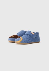 Sapatilhas azuis em feltro com uma faixa de velcro, detalhes em camurça bege e um acabamento em pele castanha na ponta. Sola em borracha para maior aderência.