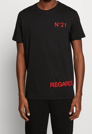 Zwart T-shirt met korte mouwen met rode tekst "N°21" op de linker bovenborst en "REGARDE" dicht bij de onderste zoom aan de rechterkant.