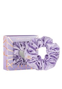 Fioletowa jedwabna gumka do włosów w pudełku, z błyszczącą teksturą i metką z napisem "CRYSTALLOVE". Pudełko ma geometryczny wzór ze złotymi akcentami.
