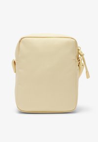 Kleine rechteckige beige Umhängetasche mit abgerundeten Kanten, Reißverschluss und verstellbarem Schulterriemen, dargestellt vor weißem Hintergrund.