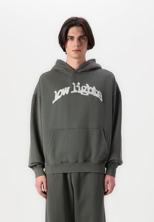 Te grote grijze hoodie heeft een voorzak en is voorzien van de tekst "low lights" in witte stiksel over de borst. Gemaakt van zacht katoen en met ribgebreide boorden.