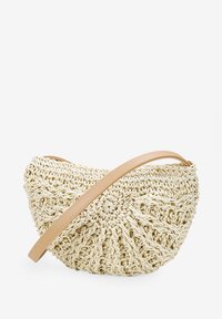 Bolso de ganchillo en color blanco roto con forma redondeada, que presenta una correa de imitación cuero marrón y detalles de costura texturizada e intrincada.