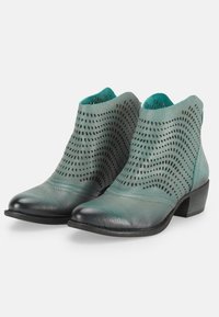Miętowe botki na niskim słupku z perforowanymi wzorami pokrywającymi górną część ze skóry.