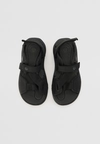 Černé sandály mají nastavitelné pásky, texturovanou podrážku a tvarovanou stélku. Vyrobeny ze syntetických materiálů s minimalistickým designem.