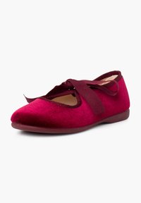 Bailarinas de terciopelo burdeos profundo, con punta redondeada, laterales recortados y una cinta a juego para un ajuste seguro. Suela plana de goma.