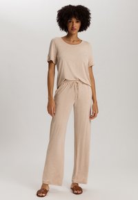 Beige tweedelig lounge set met een top met korte mouwen en wijde broek met een verstelbare koord taille, gemaakt van zachte, lichte stof.
