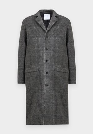 Hallide mustriga ülekaal, millel on sälguga krae, kuus nupu ja kaks esikot. Ülekaal on valmistatud tekstuurses villasegu kangast.