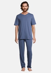 Ensemble de pyjama en coton bleu comprenant un haut à col en V à manches courtes et un pantalon ample. Texture lisse, design minimaliste et coupe décontractée.