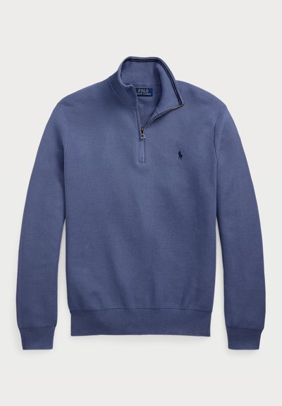 Tumši zils džemperis ar puszipsa apkakli, adīta tekstūra un izšūts logo uz krūtīm. Ribināti aproces un apakša. Viegls audums.