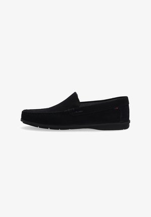 Schwarze Wildleder-Loafer mit niedrigem Profil, runder Spitze und kontrastierenden Nähten. Das Schlupfdesign verfügt über einen strukturierten Kragen und eine Gummisohle.