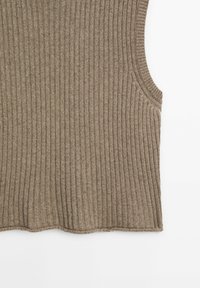 Hihaton ribbed-paita hillityssä ruskeassa värissä, jossa on teksturoitu neulekuvio ja pyöreä, aaltoileva helma.