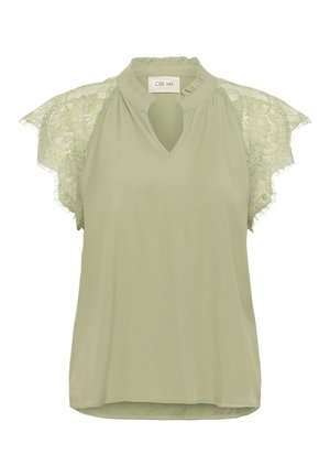 Světle zelená blůza s výstřihem ve tvaru klíčové dírky a krajkovými rukávy. Obsahuje texturovanou krajku a volný střih. Měkký materiál s hladkým povrchem.