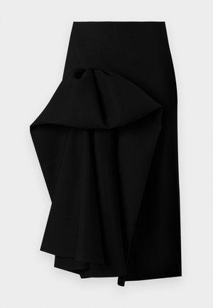 Musta hame, joka on valmistettu sileästä kankaasta ja jossa on suurikokoinen roikkuva muotoilu yhdellä puolella, luoden korkean ja matalan helman.