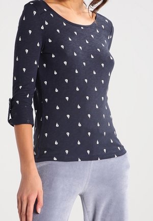 Maglietta a maniche lunghe blu navy con stampa di velieri bianchi, scollatura rotonda e maniche a tre quarti. Tessuto morbido con vestibilità comoda.