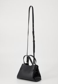 Borsa a tracolla in pelle nera con una forma strutturata, doppi manici e una lunga tracolla regolabile. Presenta accenti sottili e una superficie texturizzata.