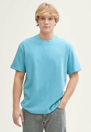 T-shirt di cotone azzurro chiaro con colletto a girocollo, maniche corte e vestibilità comoda. Motivo a costine testurizzato su tutta la stoffa.