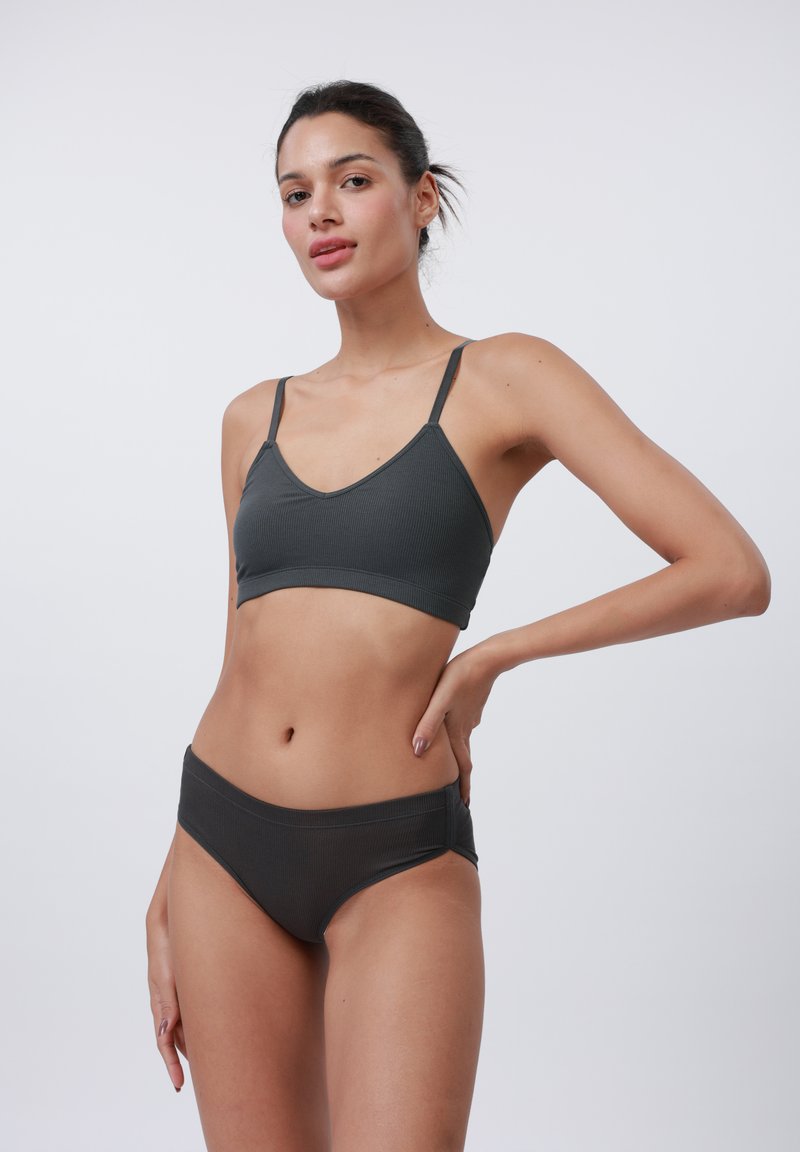 Sets of dark gray ribbed bralette and matching bikini briefs with thin straps and a smooth texture. The design features a v-neckline and mid-rise fit.