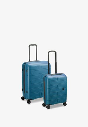 Zwei Hartschalenkoffer in matter blauer Ausführung, mit strukturierten horizontalen Rillen, Teleskopgriffen und vier Rädern für Mobilität.