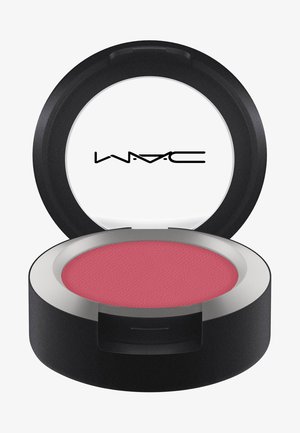 Round black compact with a silver rim, containing a textured powder blush in a muted rose hue. Features a logo on the inner lid.