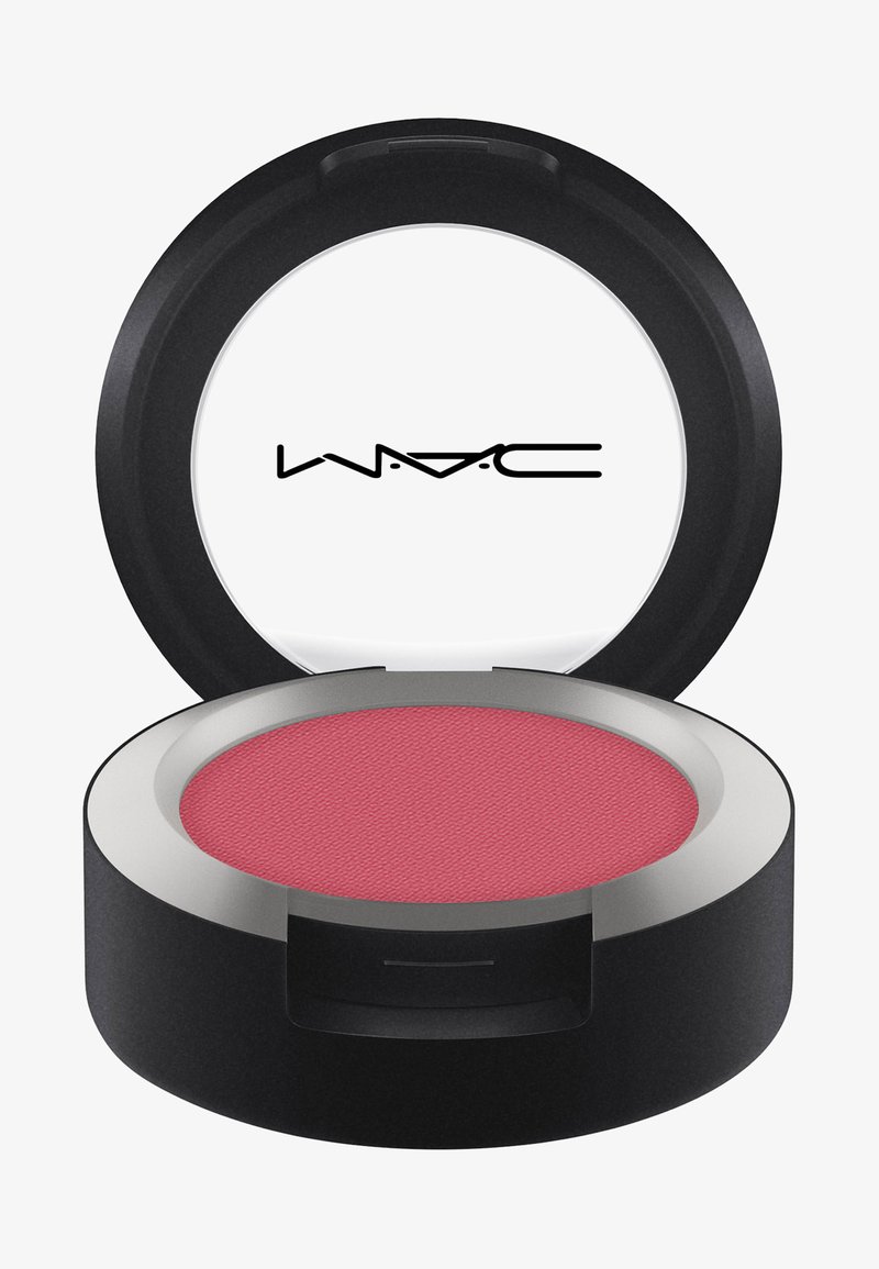 Okrągłe czarne pudełko z metalową obręczą, zawierające teksturowany róż w odcieniu stonowanego różu. Posiada logo na wewnętrznej stronie wieczka.