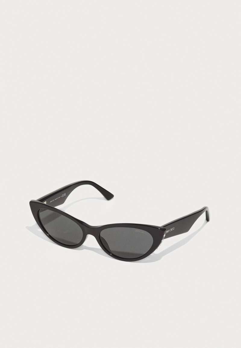 Black cat-eye sunglasses with dark lenses, glossy plastic frames, and tapered arms featuring subtle branding on the temple.