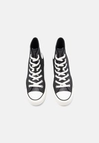 Zwarte hoge sneakers met witte veters, rubberen neuskap en een gestructureerd canvas materiaal. Heeft een rond logo aan de zijkant.