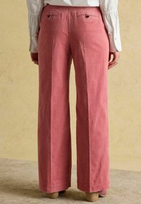 Plaša piegriezuma kordurojas bikses maigi rozā krāsā ar vertikālu ribojumu, divām aizmugurējām kabatām un gludu tekstūru.