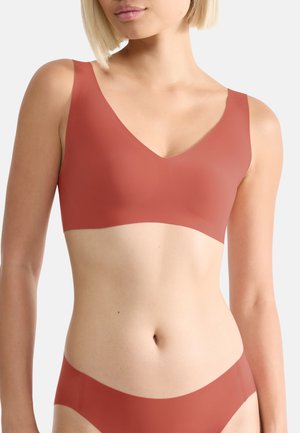 Rosa wireless Bralette mit V-Ausschnitt, aus glattem Material gefertigt. Verfügt über breite Träger und eine nahtlose Verarbeitung.
