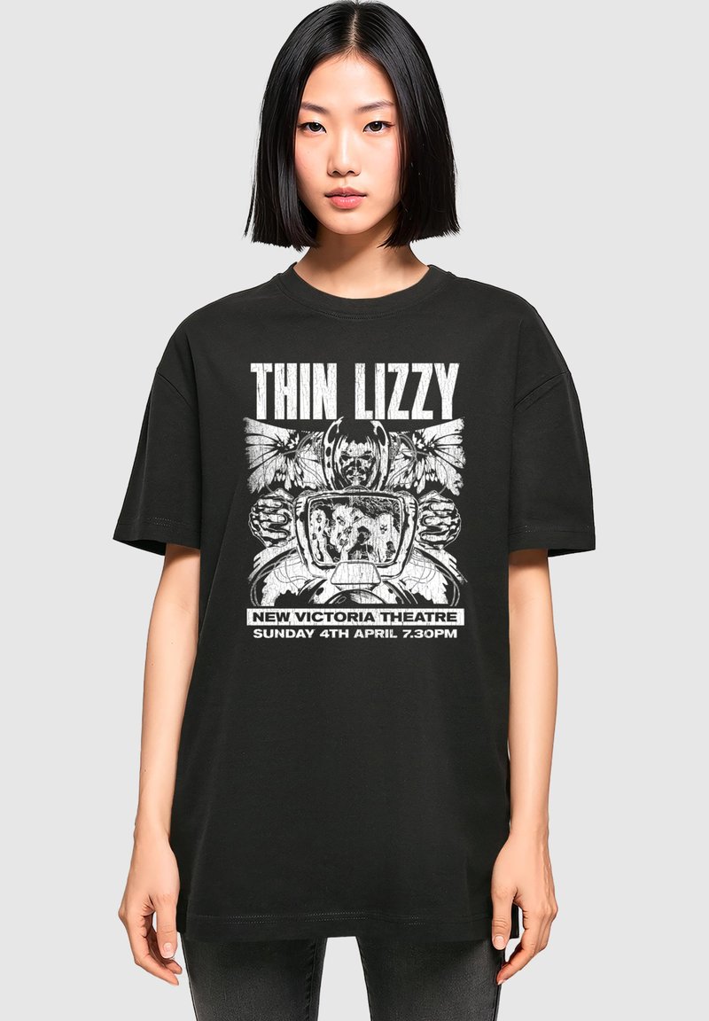 Čierne bavlnené tričko s grafickým dizajnom, na ktorom je text "Thin Lizzy", motýle a vintage televízor. Voľný strih s krátkymi rukávmi.