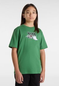Grünes Baumwoll-T-Shirt mit einem grafischen Design eines Autos und stilisierter Schrift. Kurzärmel und Rundhalsausschnitt; normale Passform.