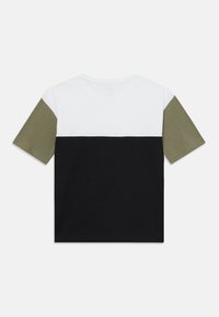 T-shirt à manches courtes avec un design en blocs de couleurs comprenant des sections blanches, vert olive et noires. Fabriqué en tissu en coton doux.