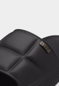 Μαύρο επενδεδυμένο σανδάλι slide με υφασμένη σόλα και μικρή μεταλλική ετικέτα λογότυπου στον ιμάντα.