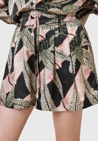 Zwarte shorts met een bladgroene en roze print, voorzien van een elastische tailleband en zachte, geweven stof met geplooide ontwerpdetails.