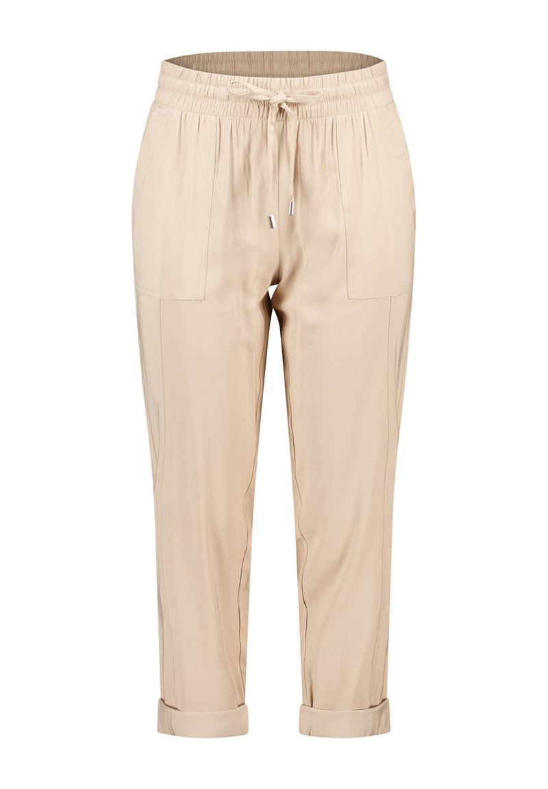 Pantalons tapered beiges avec une taille élastique et un cordon de serrage ajustable. Comprend deux poches avant et des poignets repliés. Texture de tissu lisse.