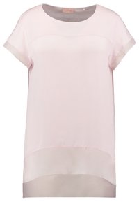 Lyserød kortærmet top med rund halsudskæring. Har et gennemsigtigt nederste lag og en glat tekstur, lavet af letvægtsstof.