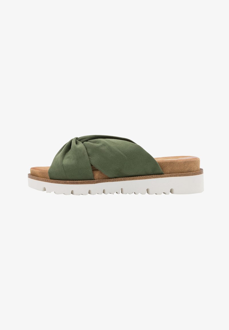 Chausson en tissu vert avec un design noué, semelle en liège beige, et une semelle en caoutchouc blanc dotée d'un motif de traction texturé.